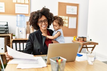 Fototapeta na wymiar Young african american woman smiling confident working with baby at office