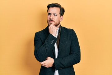 Handsome caucasian man with beard wearing elegant business jacket serious face thinking about...