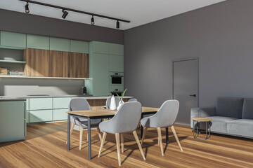 Grey kitchen set interior with dining table and four seats, sofa near door