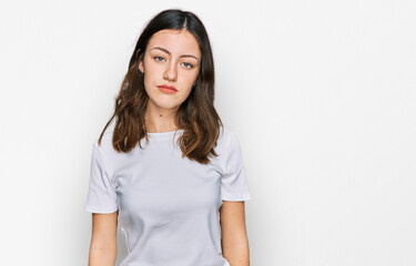 Fototapeta premium Young beautiful woman wearing casual white t shirt looking sleepy and tired, exhausted for fatigue and hangover, lazy eyes in the morning.