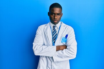 Young african american man wearing scientist uniform skeptic and nervous, disapproving expression on face with crossed arms. negative person.