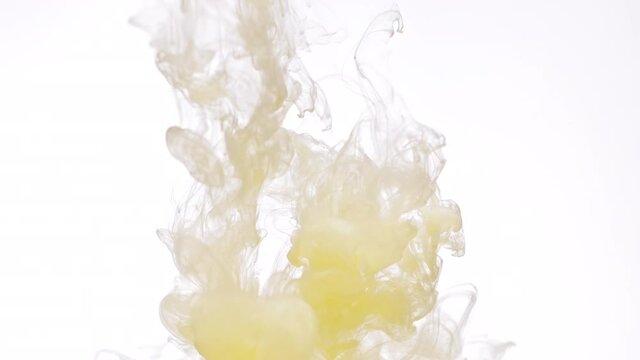 Wonderful swirls of cream yellow color paint in transparent water as decorative abstract background slow motion extreme closeup