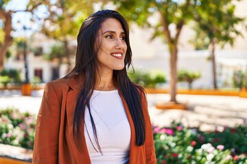 Young hispanic woman smiling confident walking at park