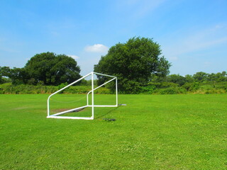 ゴールポストのある真夏の河川敷サッカー場風景