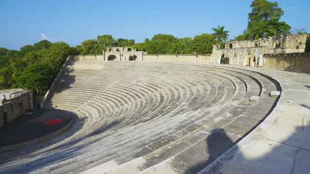The beauty of a medieval amphitheater in yellow stone. The solid stone walls are framed with delicate tropical greenery. Filmed at Altos de Chavon Republica Dominicana.