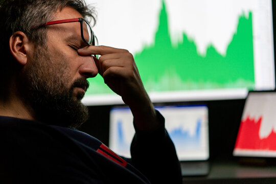 Depressed businessman in front of computer with graph of unsuccessful business on the screen. High quality photo.