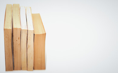 stacks of books arranged horizontally on white background high angle view