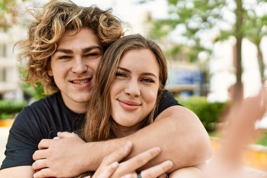 Young caucasian couple smiling happy and hugging make selfie by the camera at the city.