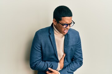 Young handsome hispanic man wearing elegant clothes and glasses with hand on stomach because nausea, painful disease feeling unwell. ache concept.