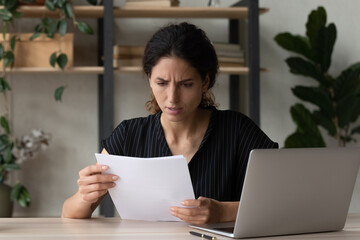 Worried unhappy latin businesswoman enterpreneur read paper letter about loan credit denial...