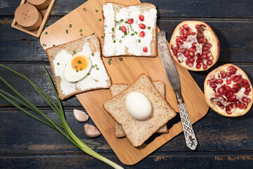 Bread has cream cheese and pomegranate on blue background.