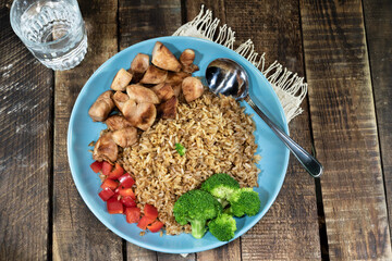 Fried rice with chicken breast has vegetable in plate close up.