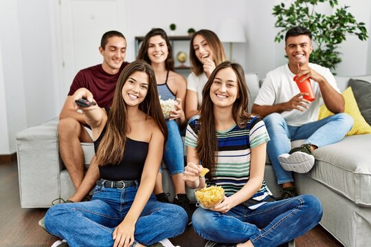 Group of young friends watching movie at home.
