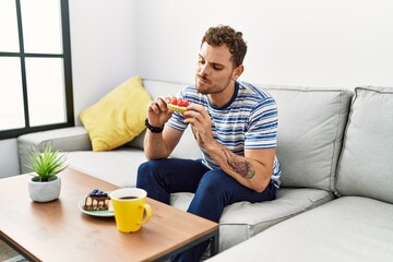 Young hispanic man having breakfast at home