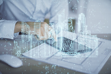 Double exposure of man's hands holding and using a digital device and city drawing.