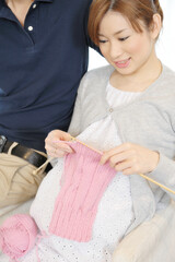 編み物をする妊婦と寄り添う夫