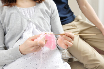 編み物をする妊婦と寄り添う夫