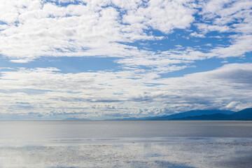 view to the Strait of Georgia from Iona Beach Regional Park azure water cloudy blue sky