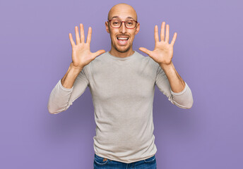 Fototapeta premium Bald man with beard wearing casual clothes and glasses showing and pointing up with fingers number ten while smiling confident and happy.