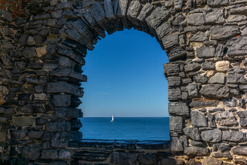 A sailing boat on the sea seen from a castle window in Porto Venere in Italy