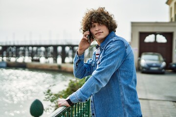 Young hispanic man speaking on the phone at marina port