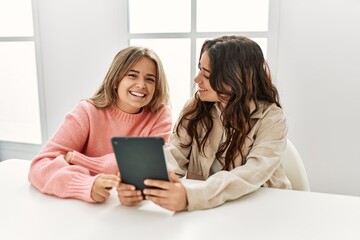 Young couple smiling happy using touchpad at home.