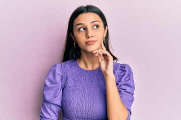 Young hispanic woman wearing casual clothes thinking concentrated about doubt with finger on chin and looking up wondering