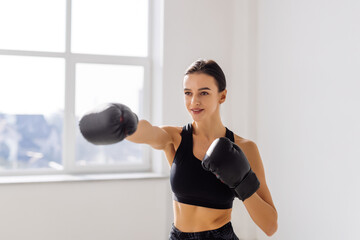 Fototapeta na wymiar Portrait of young woman boxing in gym