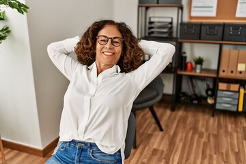Middle age hispanic woman smiling confident relaxing at office