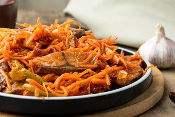 He fish with grated carrots, onions and garlic close-up. Korean salad.