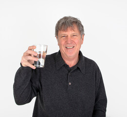 positive looking man is drinking water out of a  glass