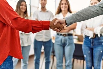 Group of business workers looking partners handshake at the office.