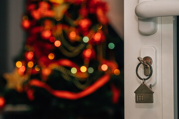 keys in open door lock with christmas tree inside house