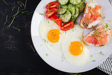 Diet breakfast. Fried eggs and sandwiches with salt salmon  and fresh salad.  Top view, overhead