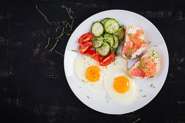 Diet breakfast. Fried eggs and sandwiches with salt salmon  and fresh salad.  Top view, overhead