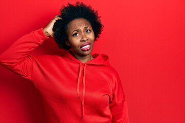 Young african american woman wearing casual sweatshirt confuse and wonder about question. uncertain...