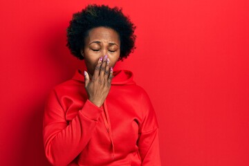 Young african american woman wearing casual sweatshirt bored yawning tired covering mouth with hand. restless and sleepiness.