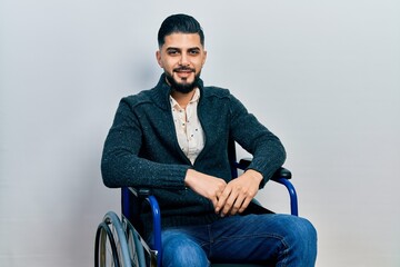 Handsome man with beard sitting on wheelchair with a happy and cool smile on face. lucky person.