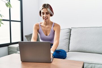 Young caucasian girl using smartphone sitting on the sofa at home.