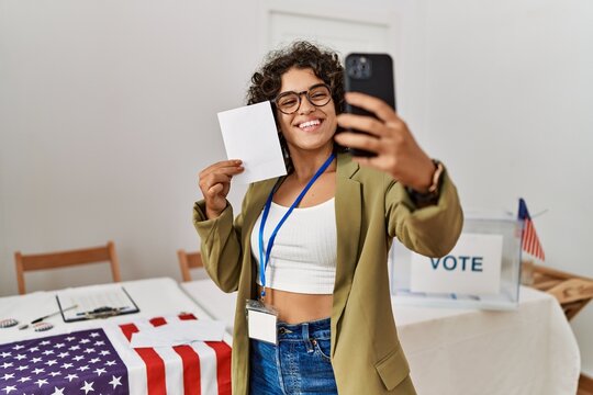 Young hispanic woman holding vote make selfie by the smartphone at electoral college