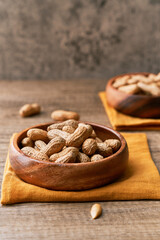Image of bunch of peanuts in a bowl on a wooden table