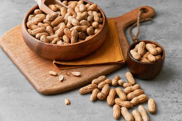 Image of wooden spoons with peanuts on a concrete surface