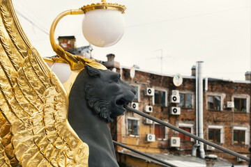 Saint Petersburg, Russia - March 2021: Sculptures of Griffin with golden wings on the Bank bridge