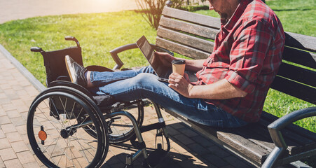 Obraz premium Freelancer with a physical disability in a wheelchair working at the park