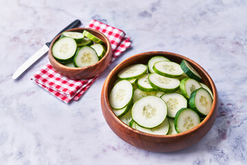  Bowls of slices of cucumber on a marble surface