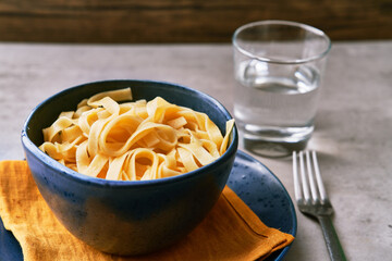  Bowl of fettuccine italian pasta on a concrete surface