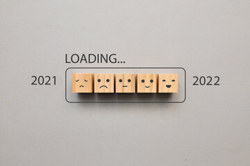 Wooden cubes in the form of batteries and the inscription: 2021, 2022 and loading. The coming of...
