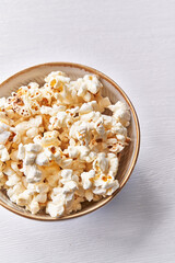  Bowl of salty popcorns isolated on a white background