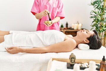 Middle age hispanic woman having aromatic treatment at beauty center