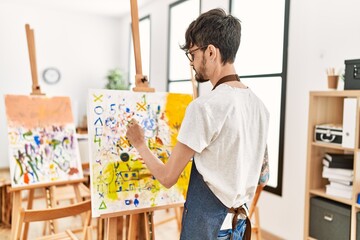 Young hispanic artist man concentrate drawing at art studio.